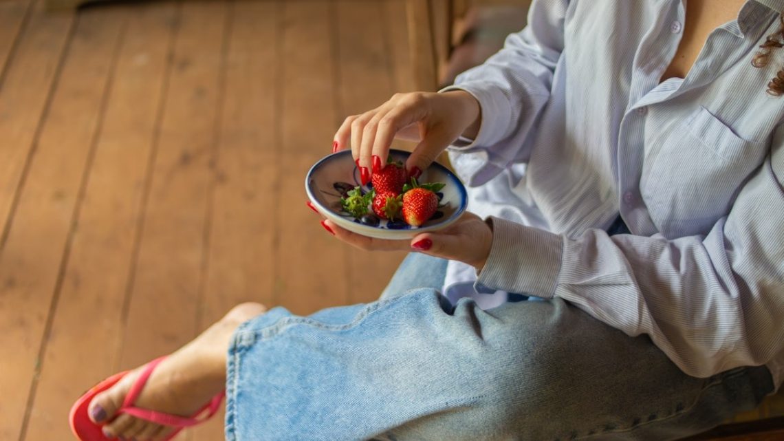 Fresh strawberries served in a ceramic bowl, capturing a simple and healthy lifestyle moment in a rustic countryside setting.